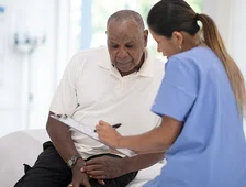 man and healthcare worker looking over clipboard